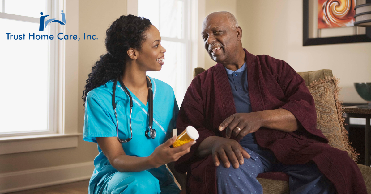 Home Care Nursing Assistant kneels next to an elderly man holding a pill bottle