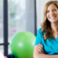 A physical therapist smiles as a result of enjoying her career.