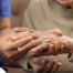A nurse check where a patient’s hand is hurting in order to help with pain management.