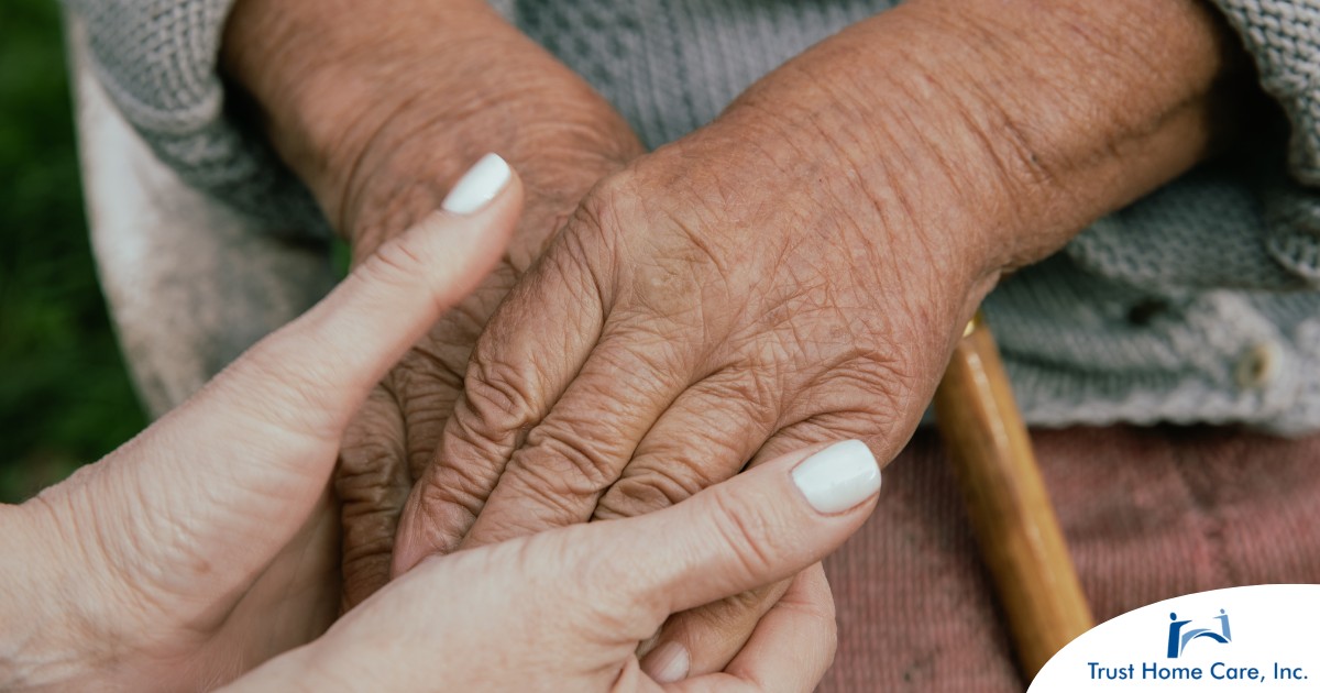 A caregiver holding an older adult's hands represents the support that hospice care can bring.