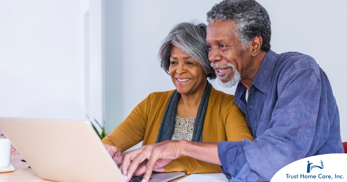 A senior couple looks at a computer, representing older adults looking for payment options for home health care.