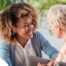 A caregiver warmly speaks with an older client, representing the quality communication that can come with bilingual care.