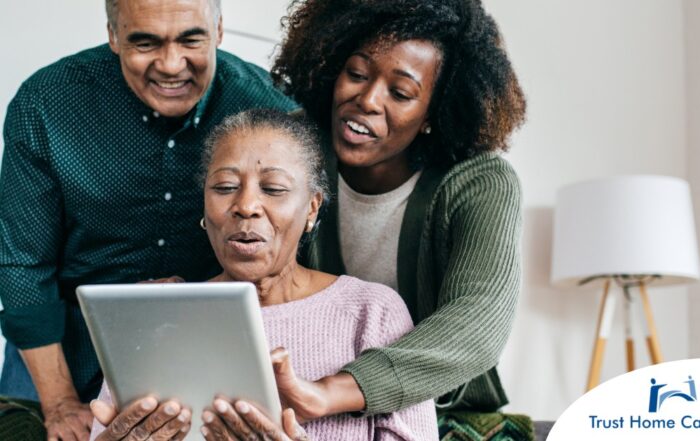 A daughter looks at a tablet with her older parents, representing technology and how ti can help with aging in place.
