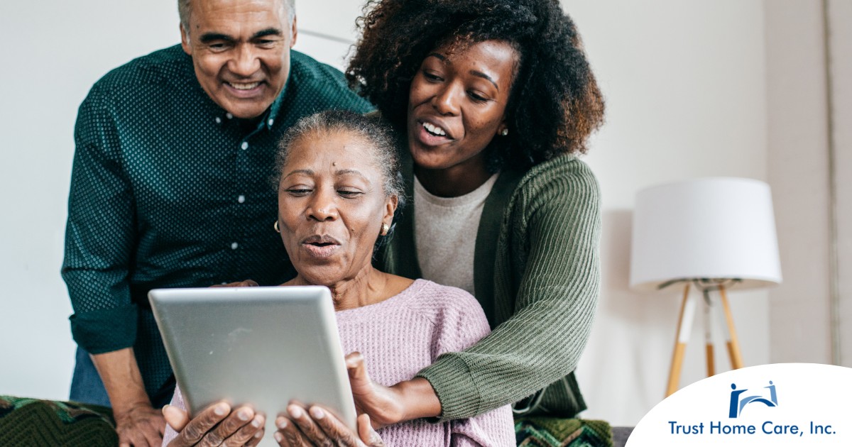 A daughter looks at a tablet with her older parents, representing technology and how ti can help with aging in place.