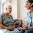 A caregiver sits and spends time with a client, representing how non-medical home care can benefit older loved ones.