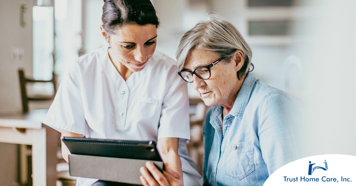 A nurse helps an older patient by showing her a tablet representing the role of tech in registered nurses’ roles in care.
