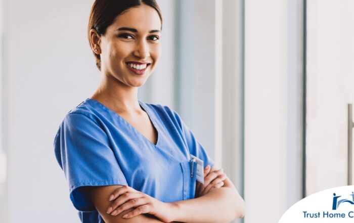 A woman in scrubs smiles representing the satisfaction of finding out how to become a home health aide.