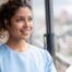 A woman smiles while looking ahead hopefully, showing the positive outlook that planning for a home care career can bring.