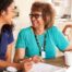A care provider smiles with an older patient, representing the good results of speech therapy.