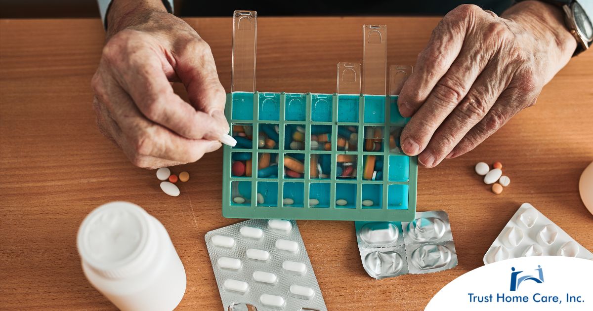 Older hands organize pills into a pill organizer, showing a great tool for managing medications.